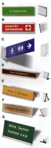 Catalog diagram showing seven types of aluminium sign holders including wall tracks, projecting signs, and desk stands.